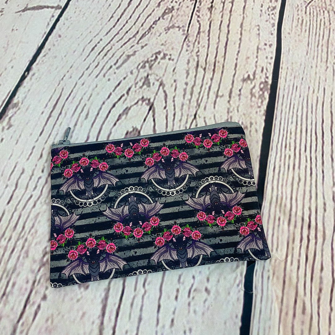 a black and white striped purse with pink flowers on it