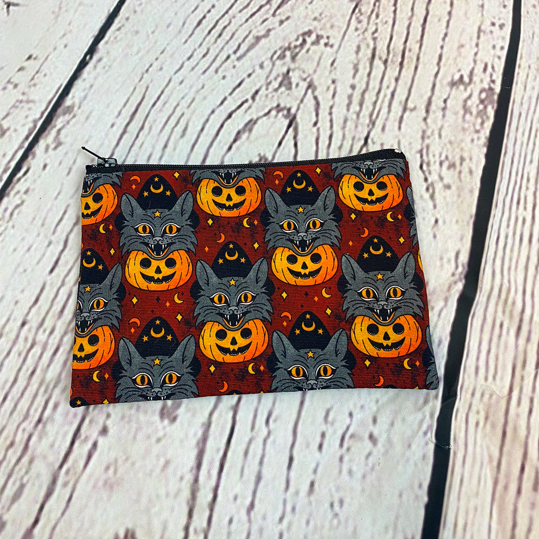 a small zipper bag with cats and pumpkins on it