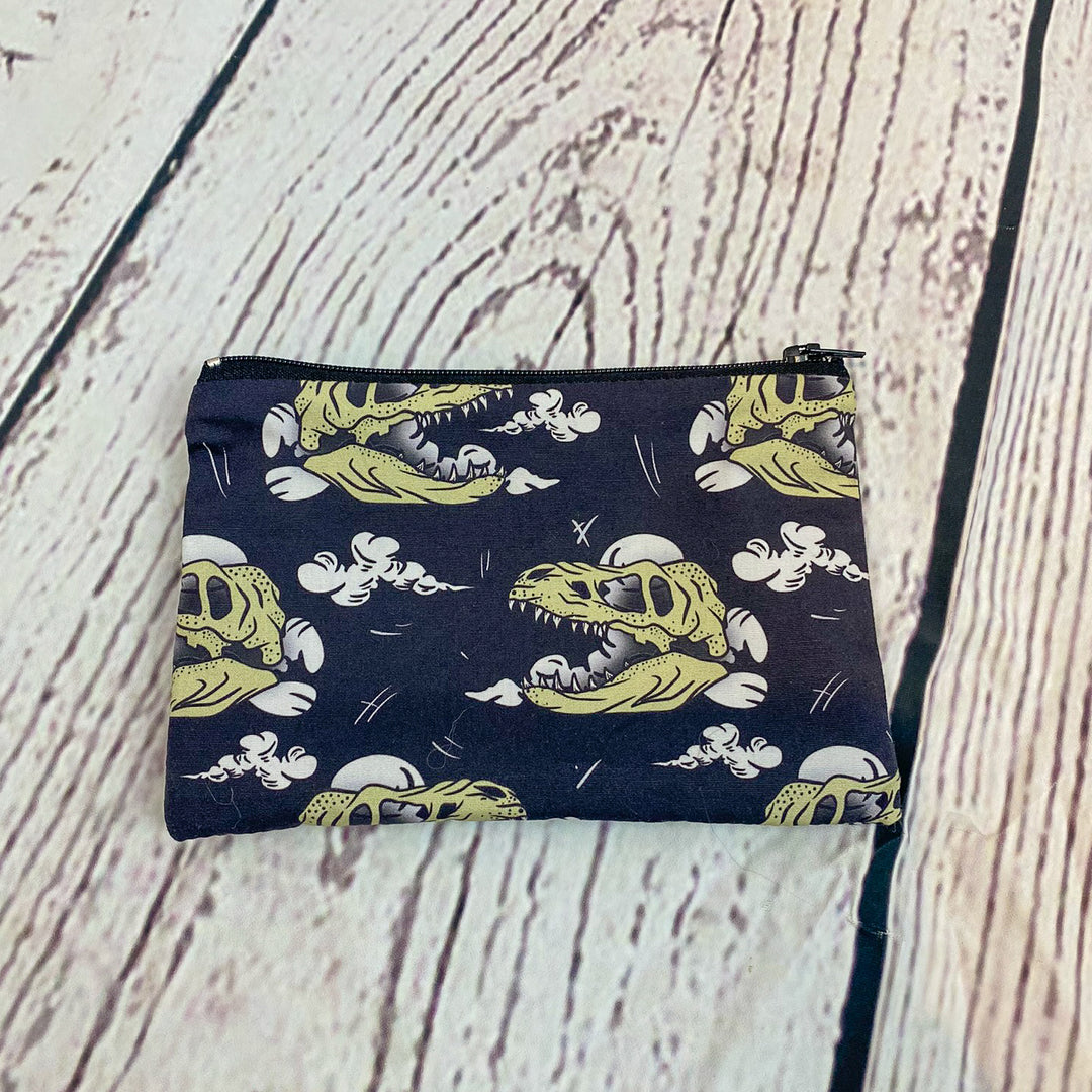 a small zipper bag with a dinosaur print on it