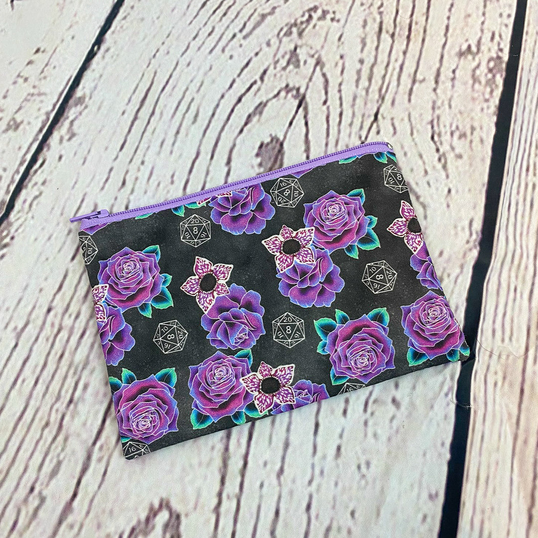 a black and purple flowered pouch sitting on top of a wooden table