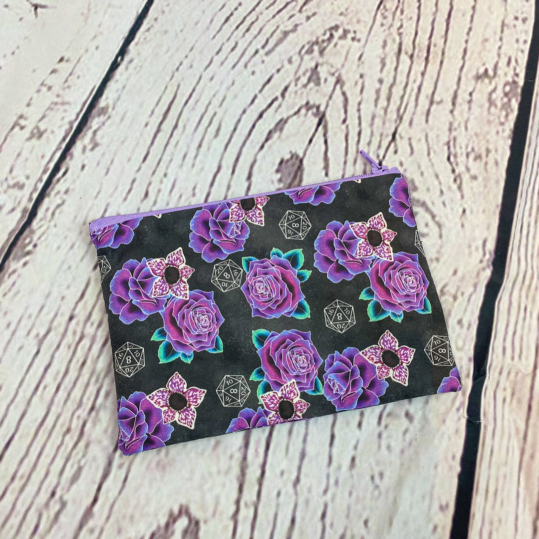 a black and purple flowered pouch sitting on top of a wooden table