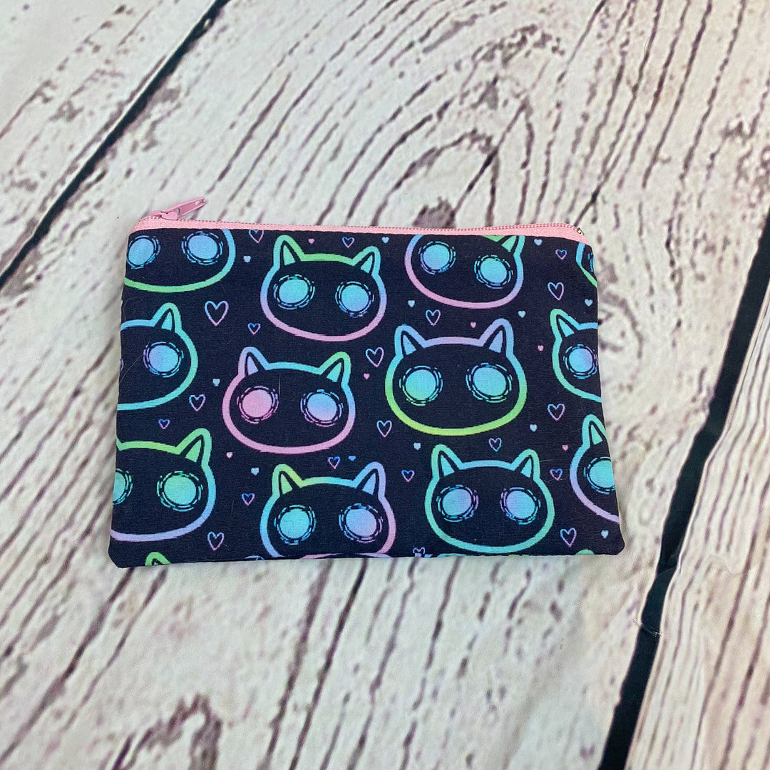 a small wallet with a cat pattern on it