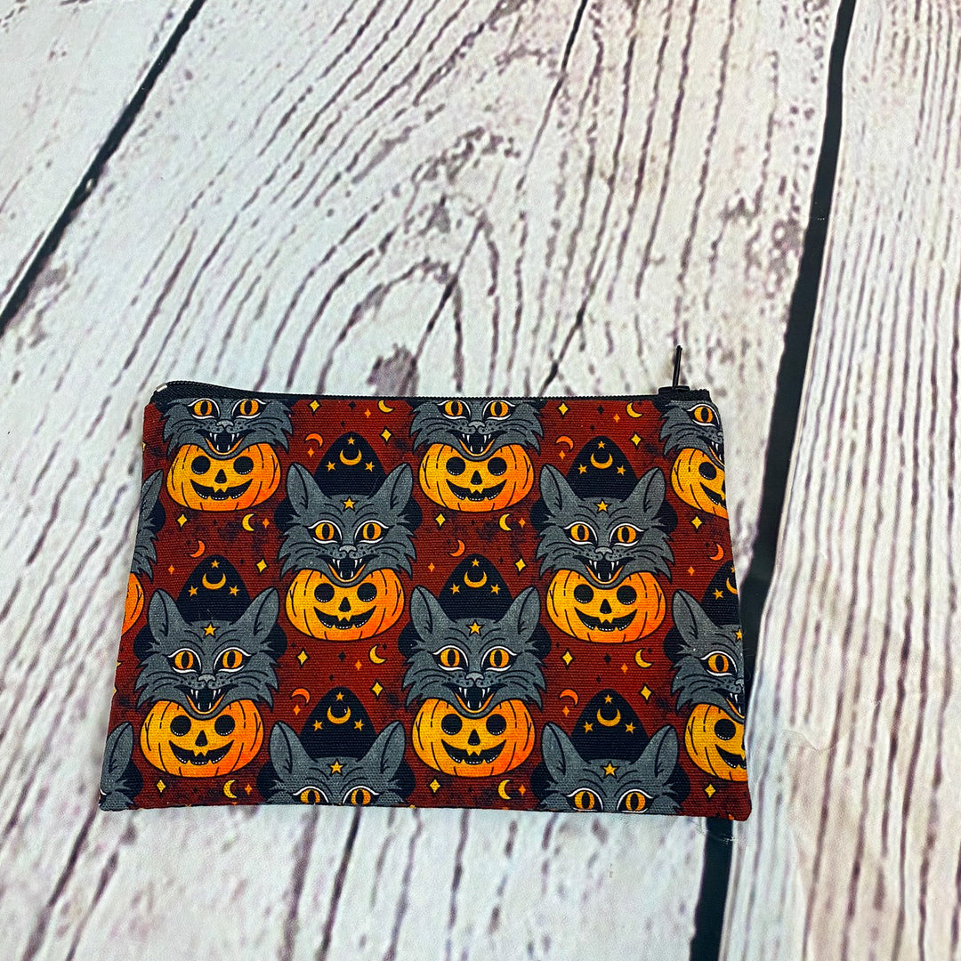 a small bag with a pattern of cats and pumpkins on it